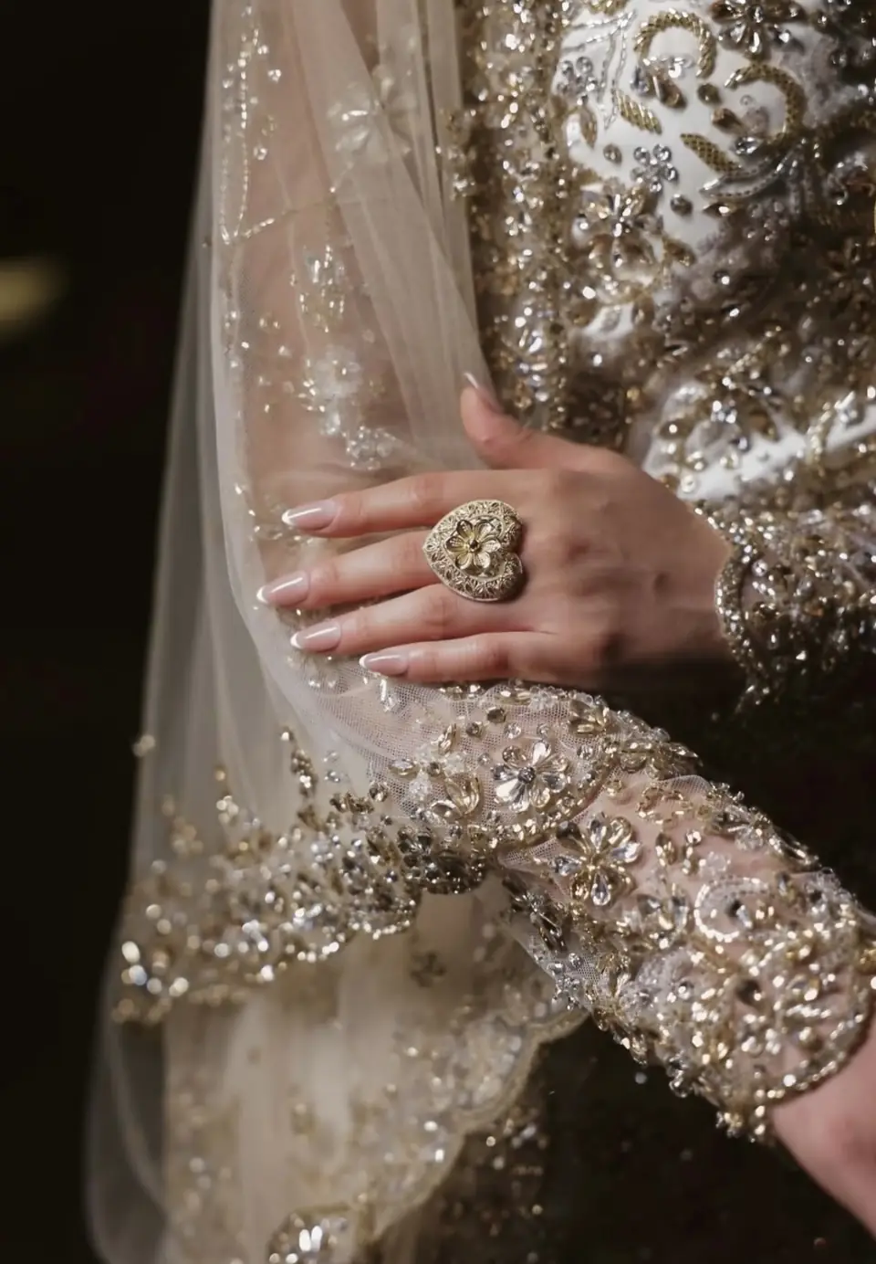 Hand-embroidered crystal and gold sleeve cuff beside a beaded tulle veil